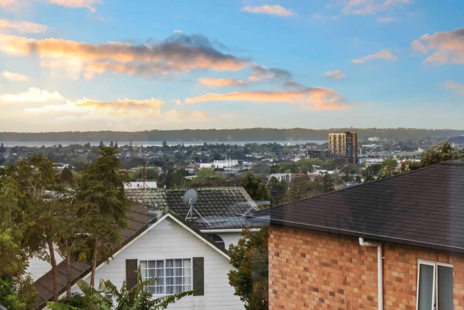 View over neighbouring roofs to the harbour at dusk, New Lynn