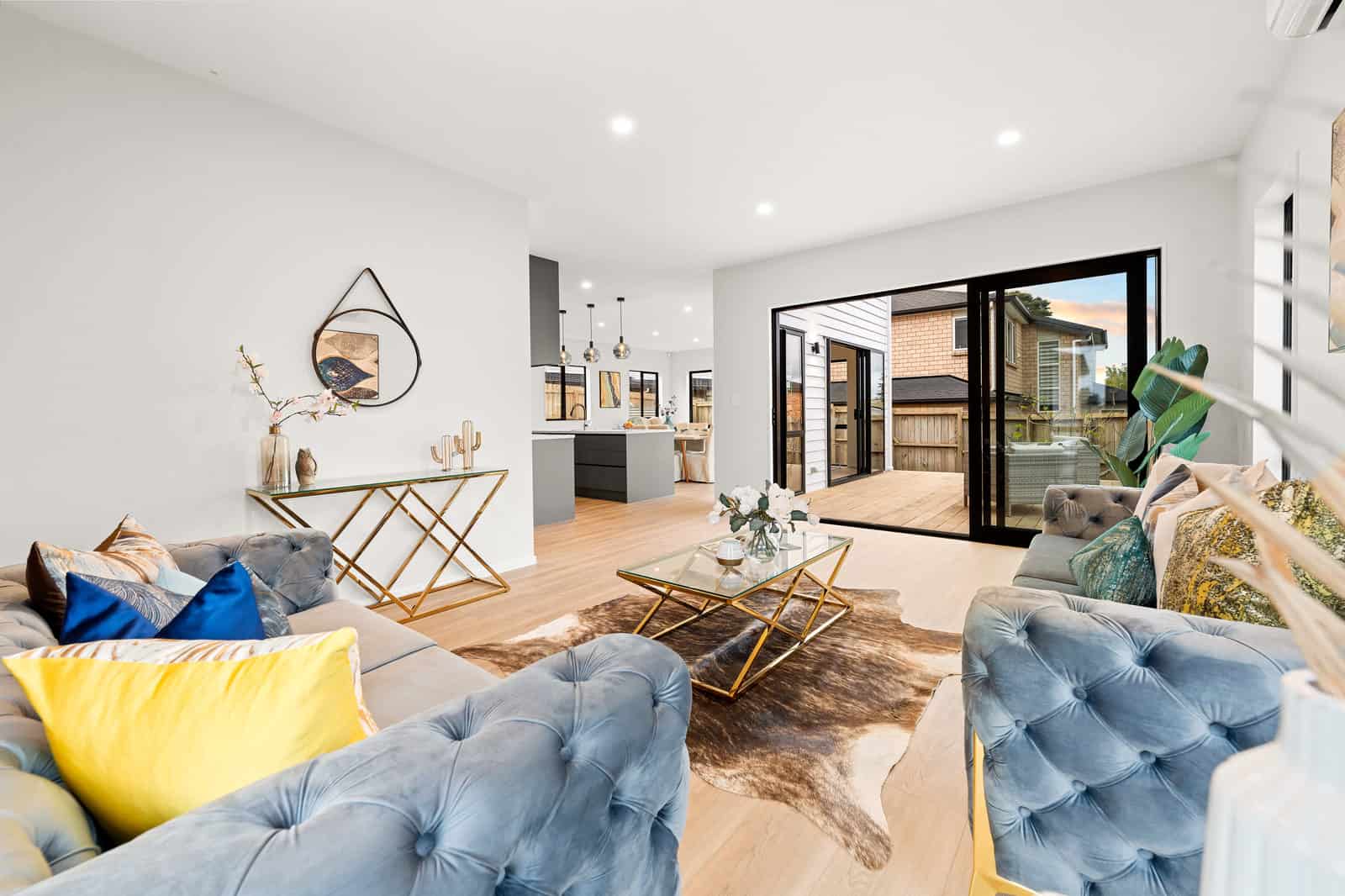 Living room with blue armchairs looking through to the kitchen and garden doors, New Lynn