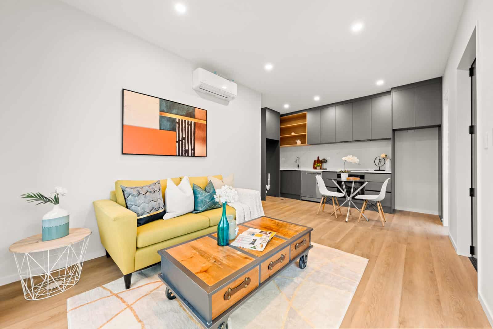 Living room with a yellow sofa looking through to the kitchen and dining, New Lynn