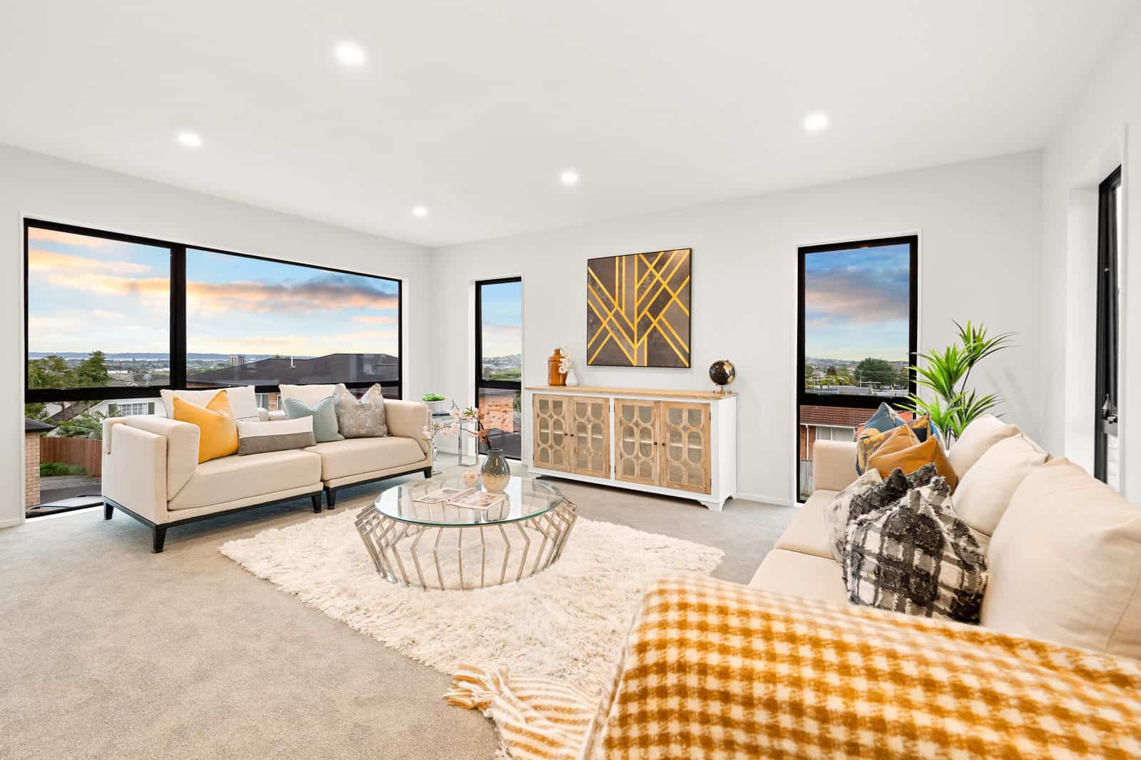 Upper living room with windows on two walls looking over the suburb at dusk, New Lynn