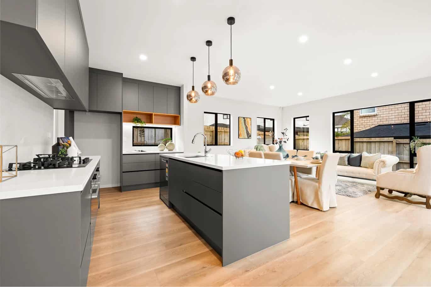 Kitchen with a dark island, gas hob and stainless rangehood, New Lynn