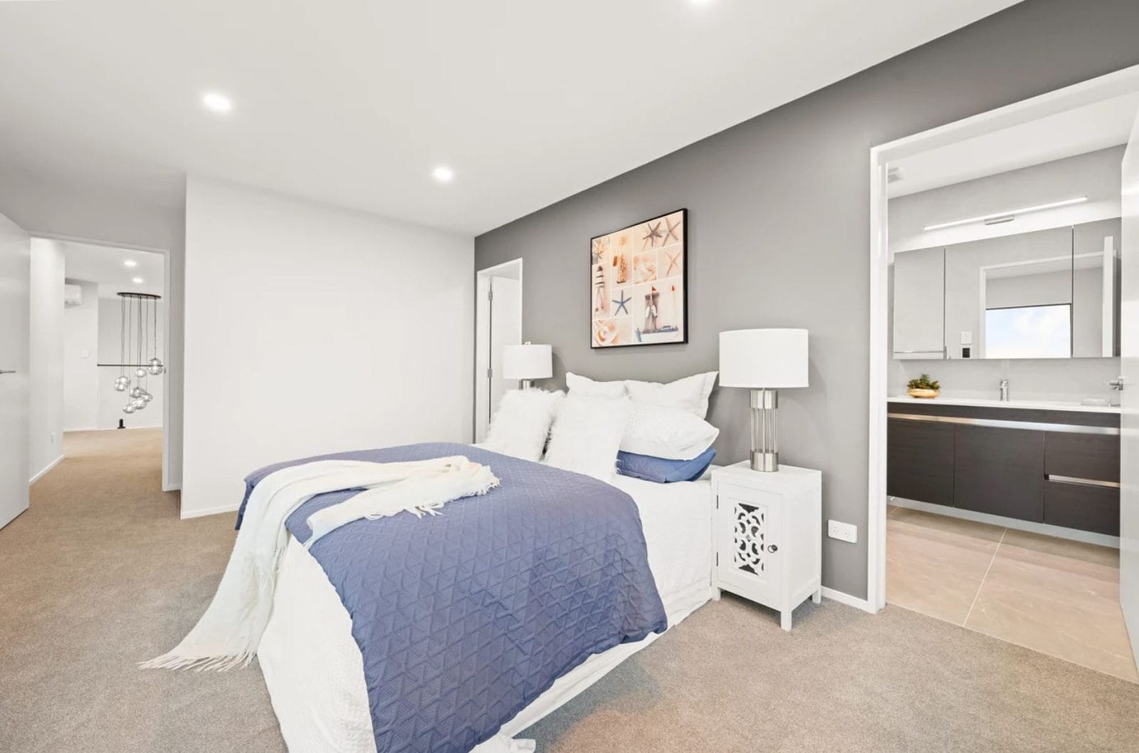 Bedroom with an ensuite through the doorway and a grey feature wall, New Lynn