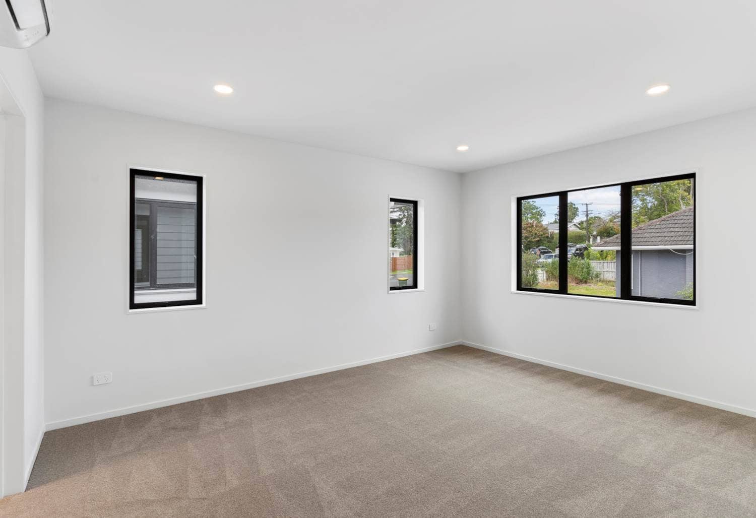 Empty bedroom with three windows and carpet, New Lynn