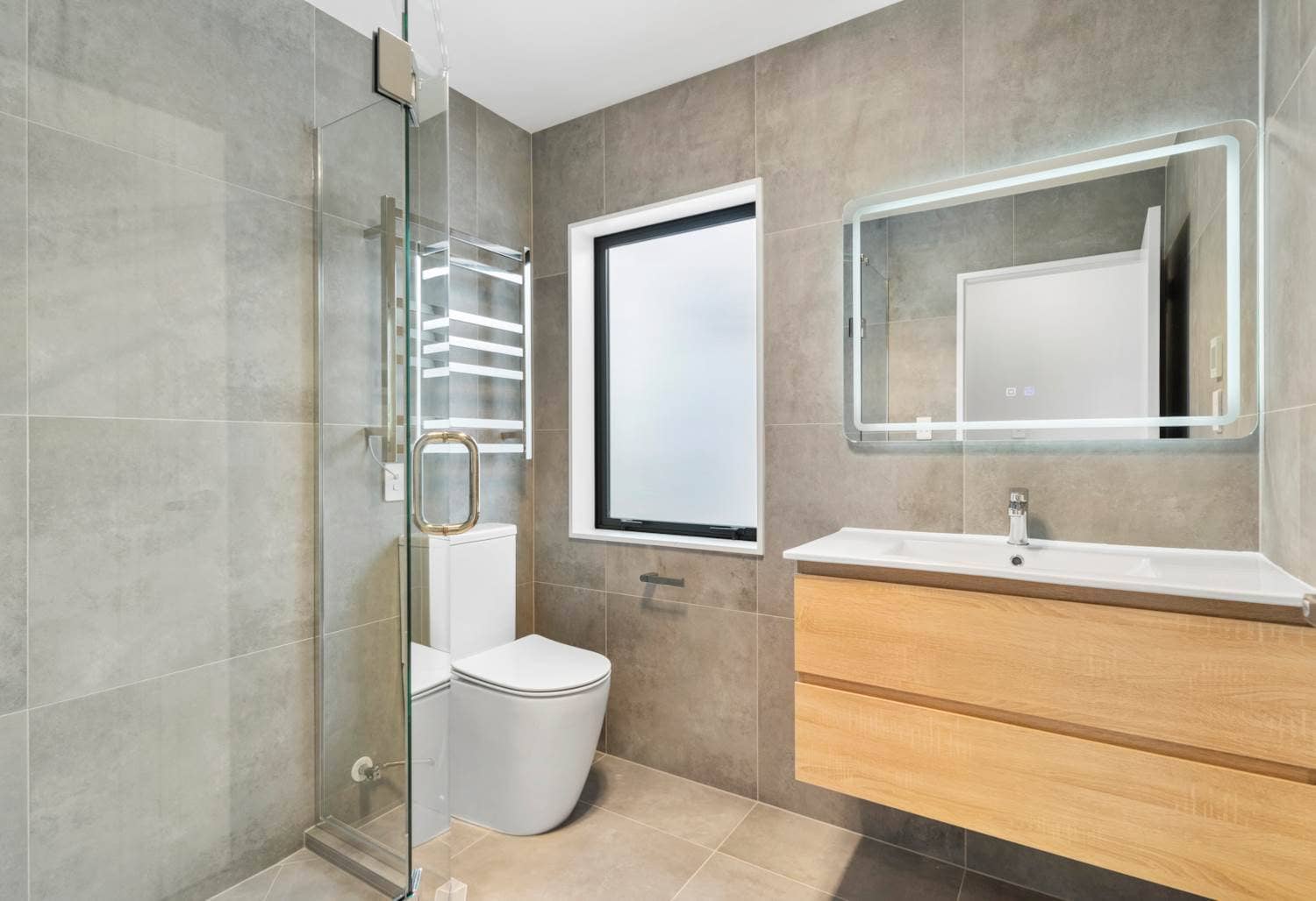 Bathroom with a backlit mirror, timber vanity, toilet and glazed shower, New Lynn