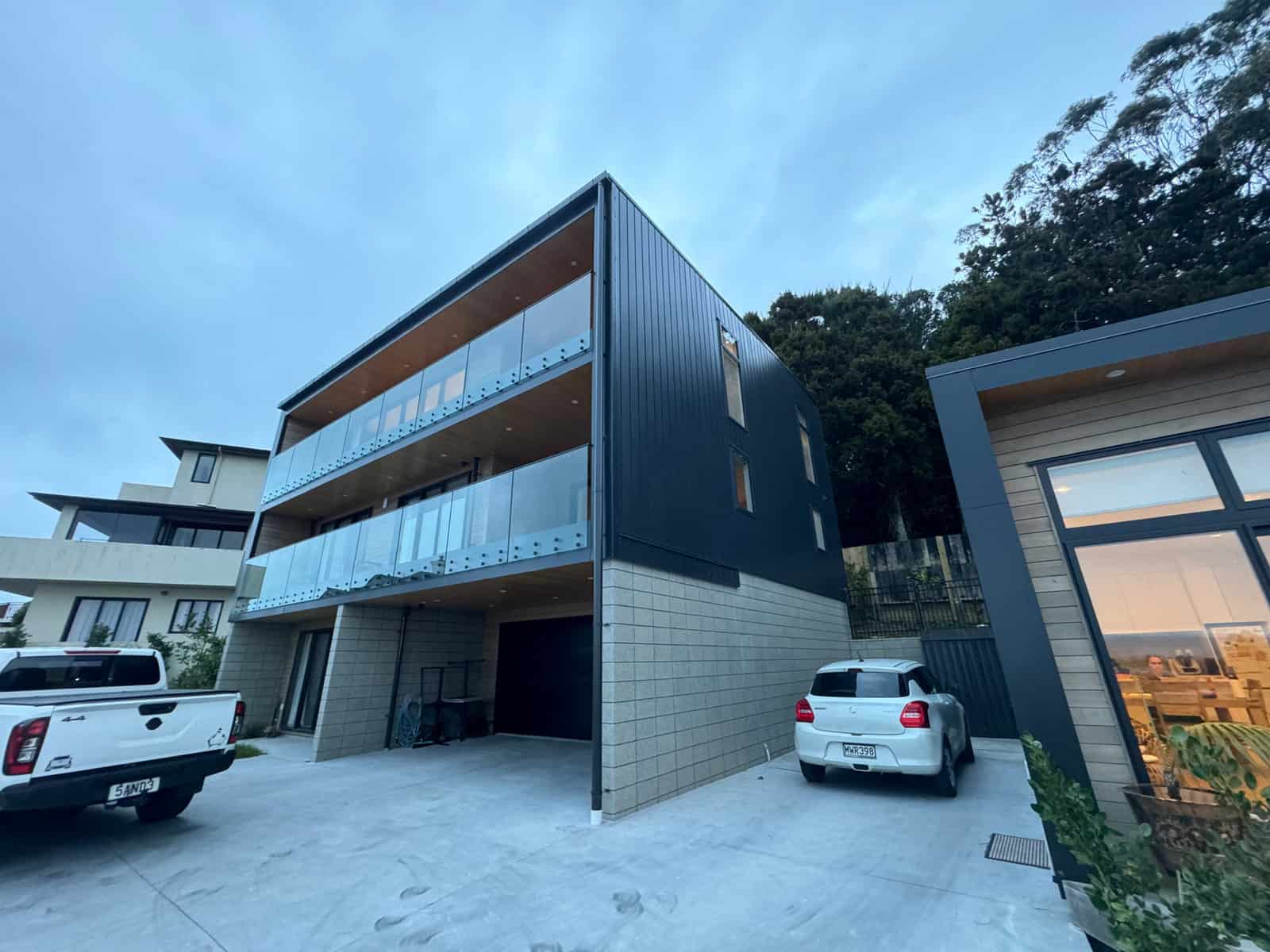Three-level house in dark cladding with stacked glazed balconies, Red Beach
