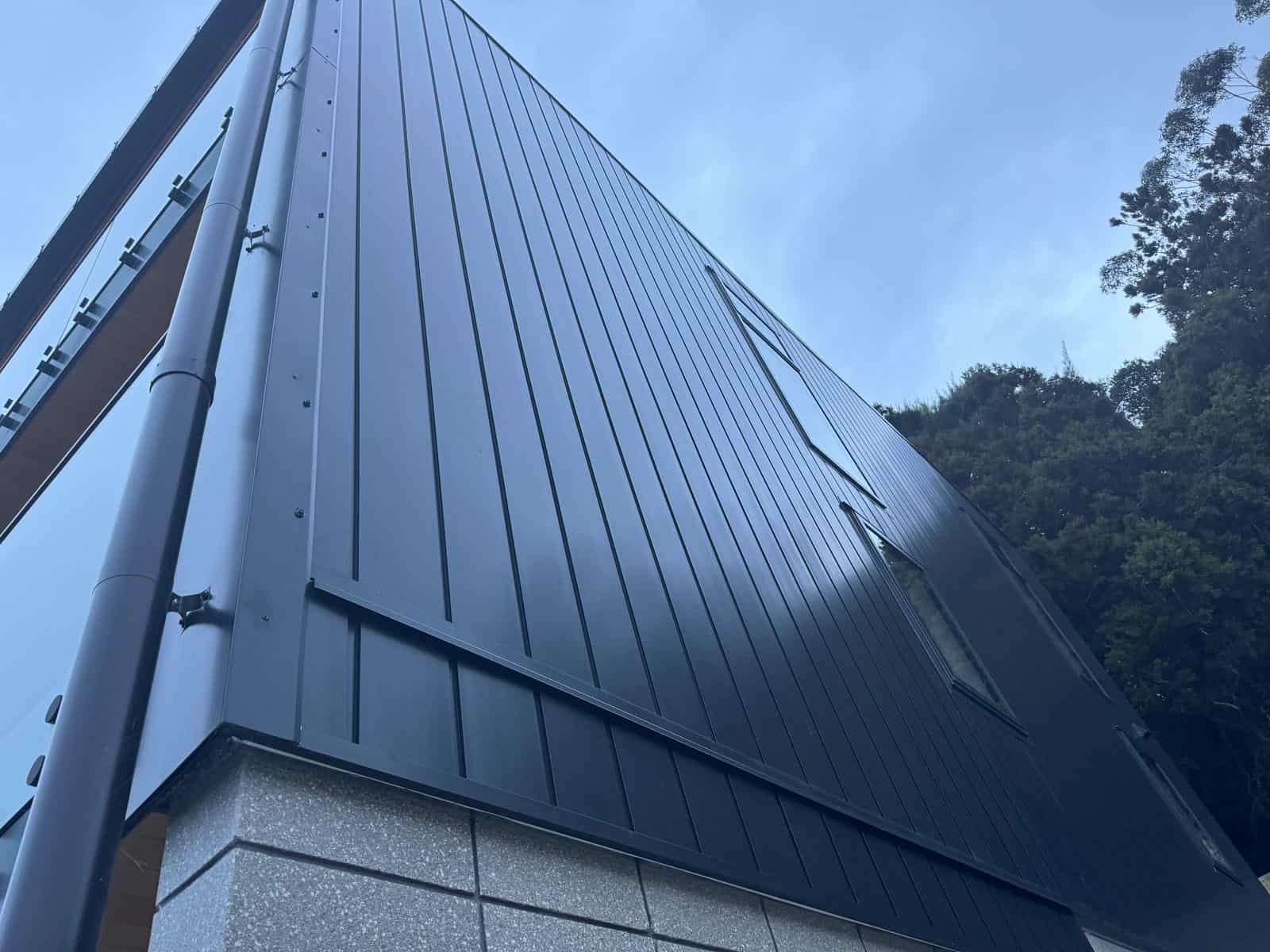 Looking up the standing-seam clad wall against the sky, Red Beach
