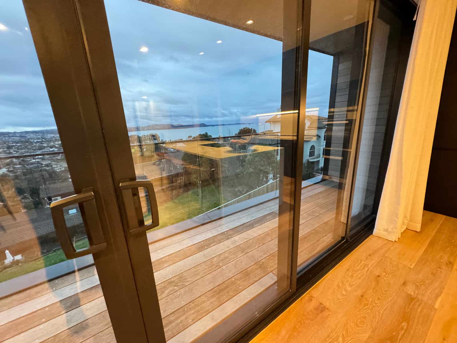 Full-height sliding doors framing the coastal outlook, Red Beach