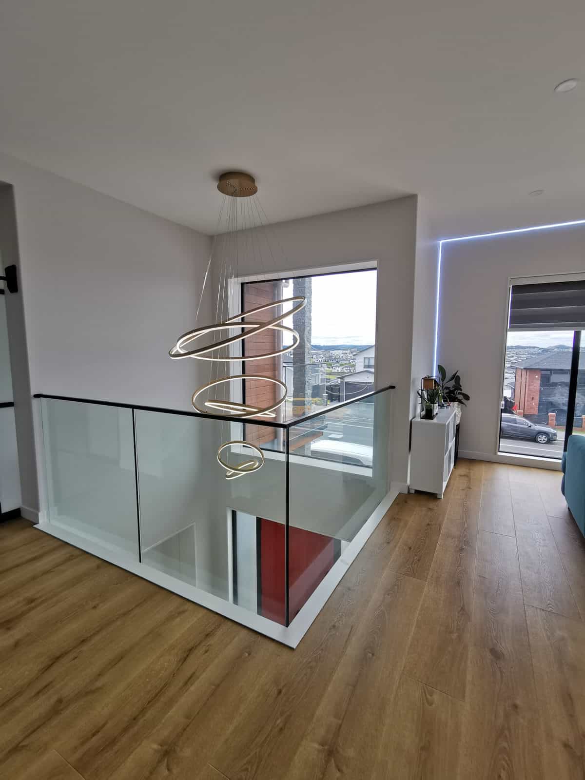 Upper landing with a glass balustrade and the ring pendant over the void, Silverdale