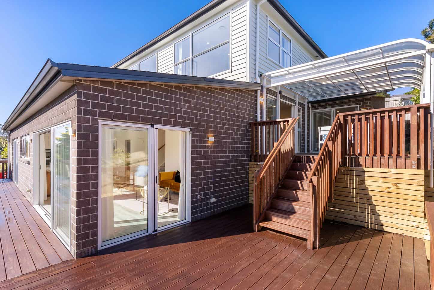 Split-level house with external timber stairs linking the raised deck to the ground, Sunnynook
