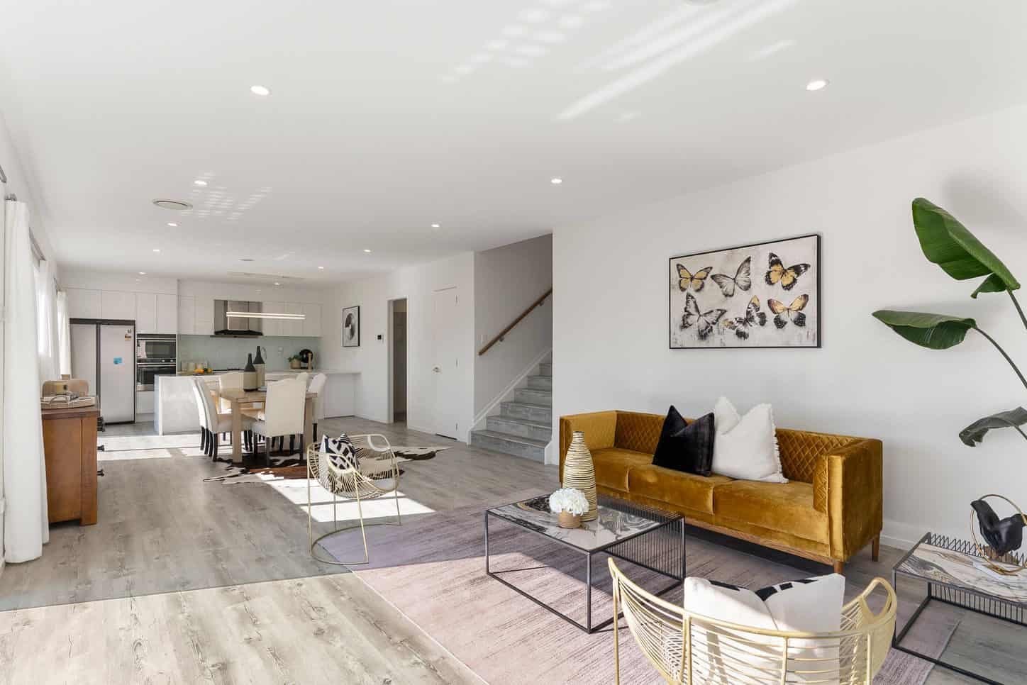 Open-plan living and dining with a mustard velvet sofa and the kitchen beyond, Sunnynook