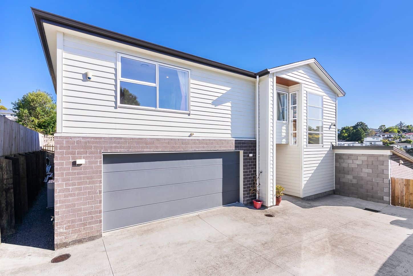 Two-storey house with a brick base, double garage and weatherboard upper level, Sunnynook