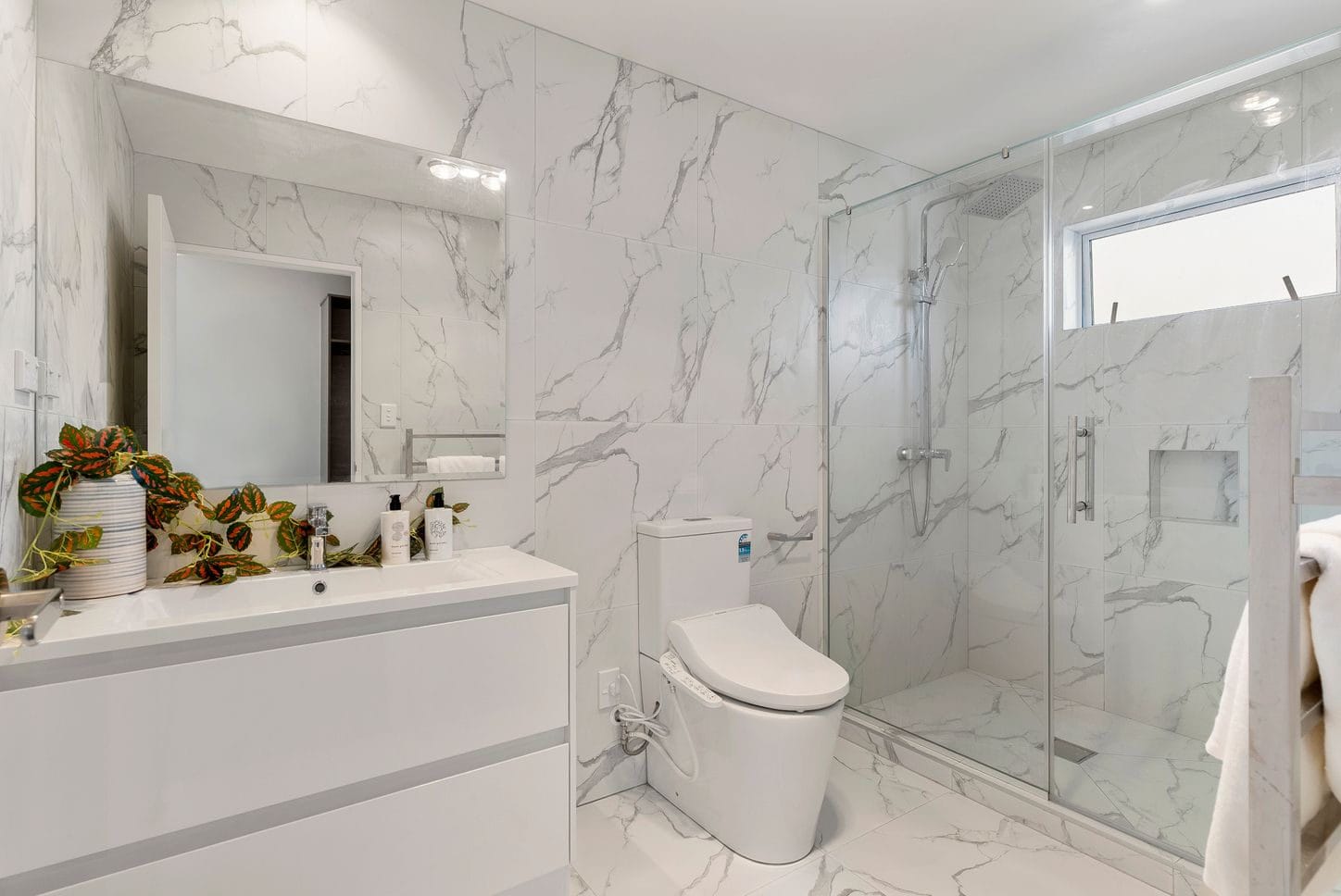 Bathroom with marble-look tiling, a wall-hung vanity, toilet and walk-in shower, Sunnynook
