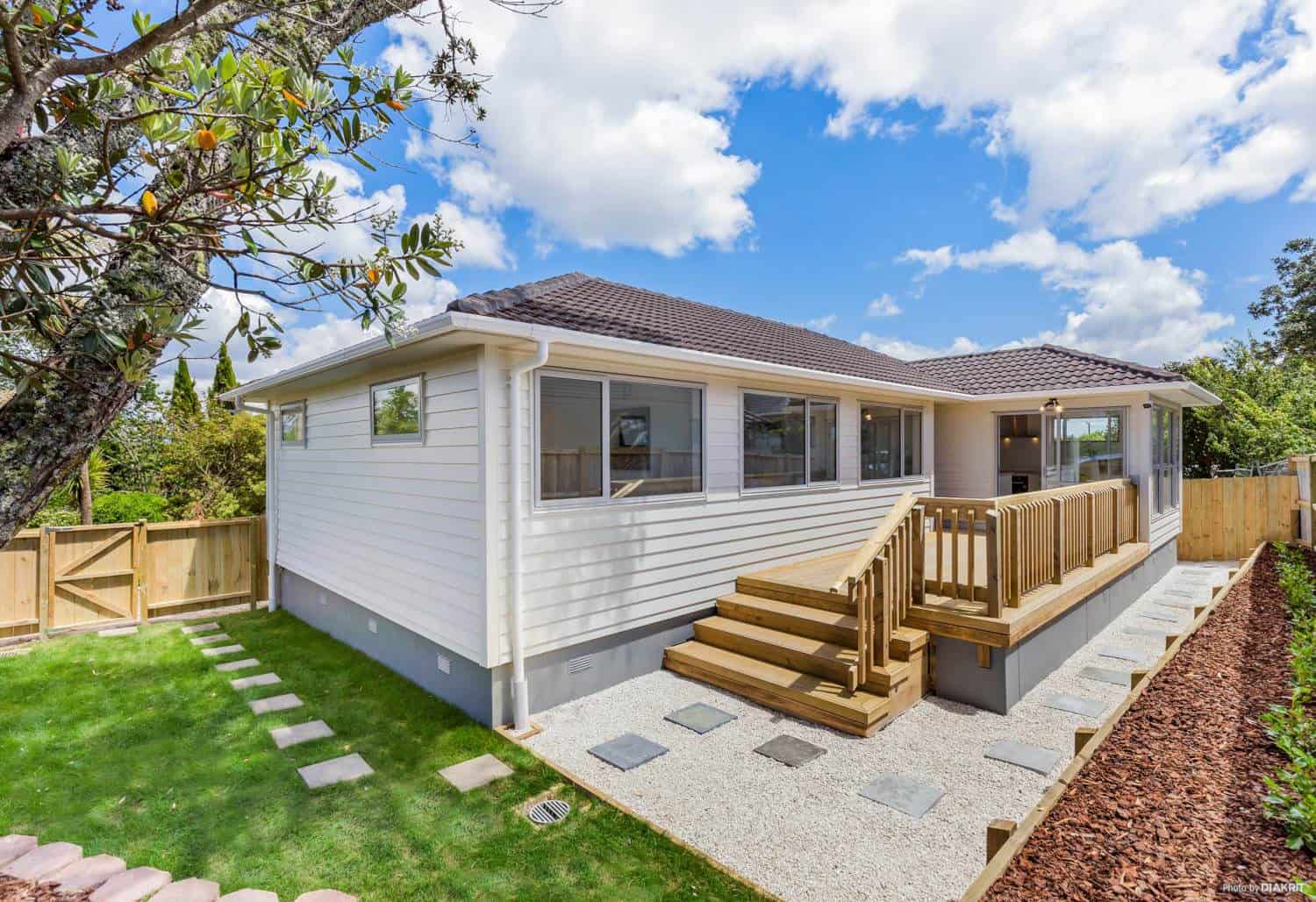 Relocated weatherboard house on new foundations with timber entry steps, Te Atatu South