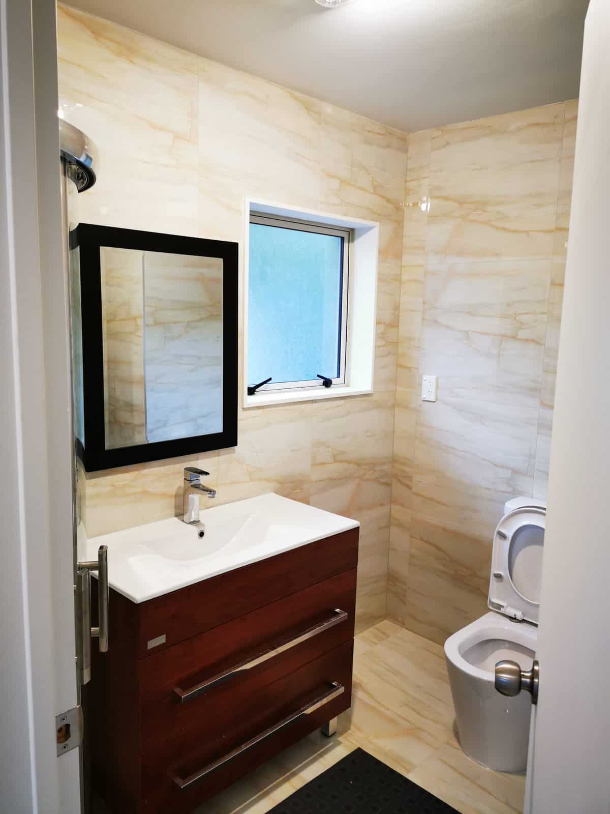 Bathroom with a timber vanity, mirror, window and toilet, The Gardens