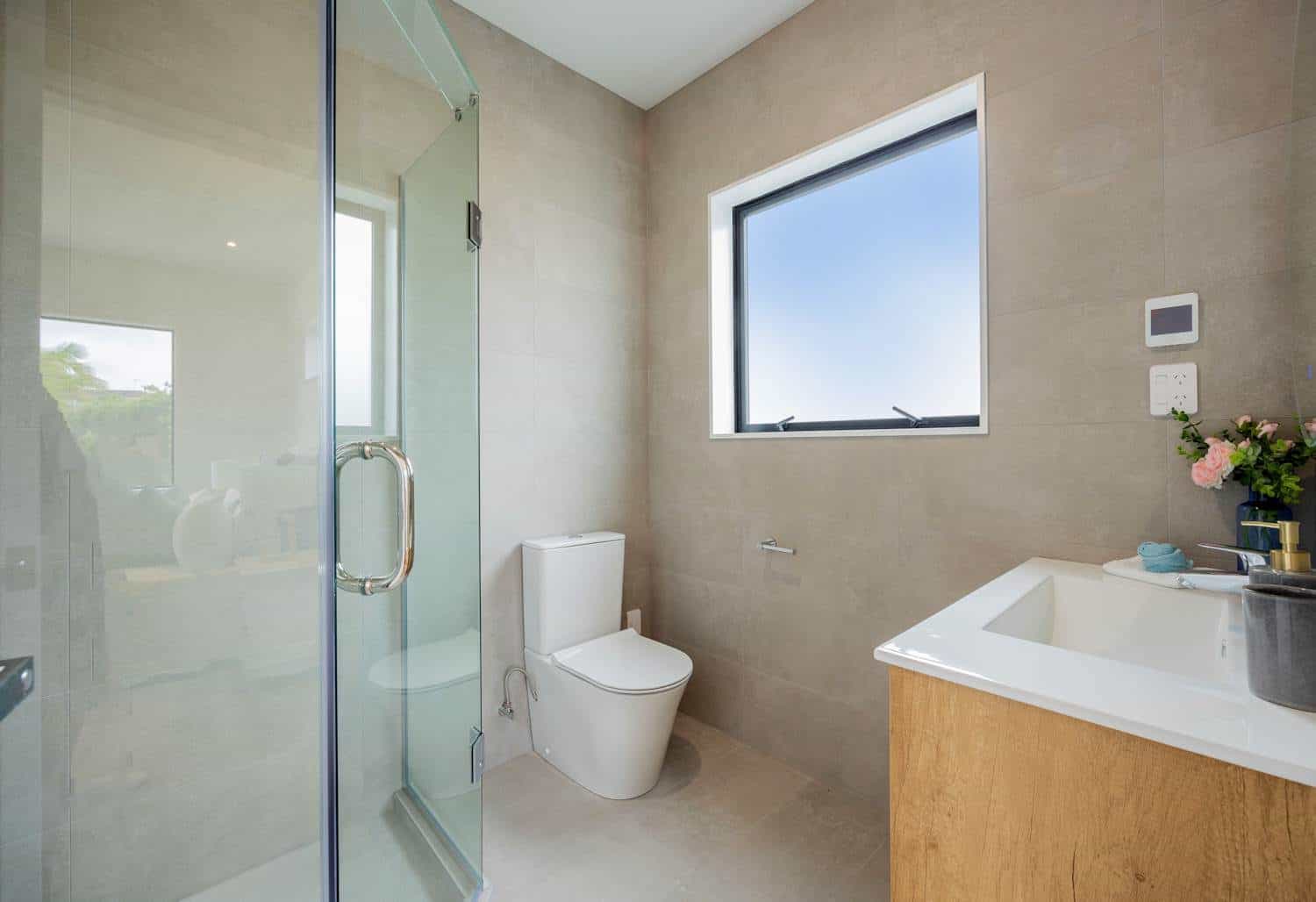 Bathroom with a timber vanity, toilet and glazed shower, Torbay