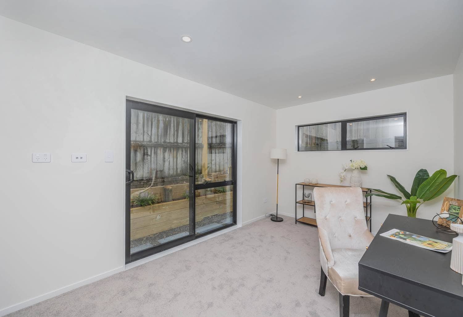 Bedroom with a sliding door onto a fenced courtyard and a desk alongside, Torbay