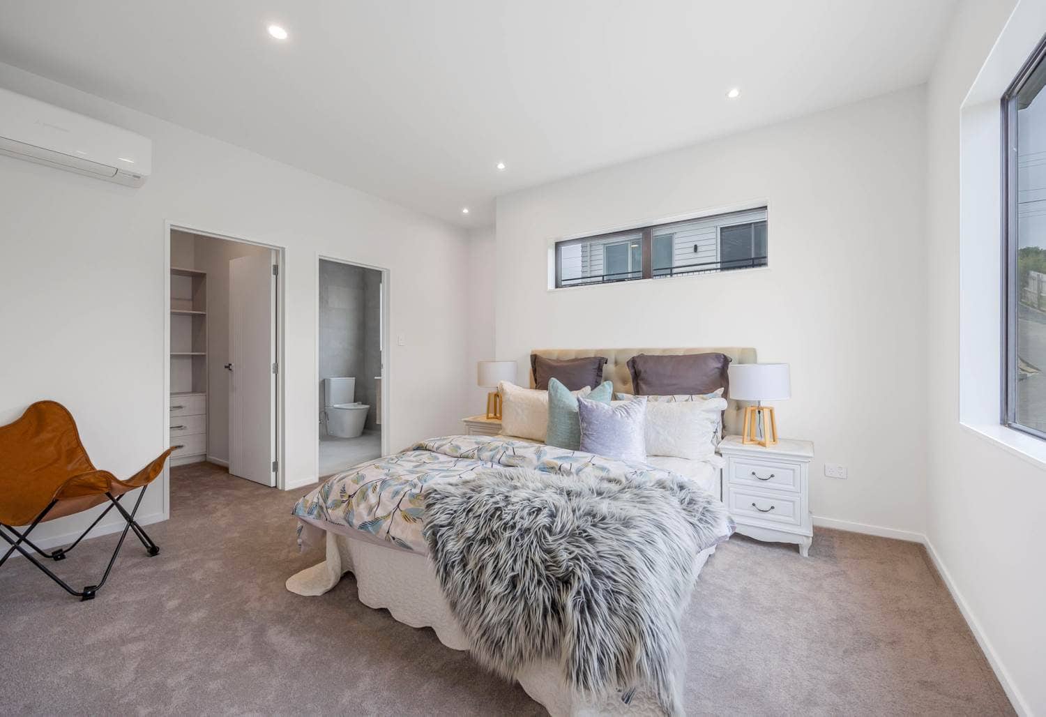Bedroom with an ensuite through the doorway and windows on two walls, Torbay