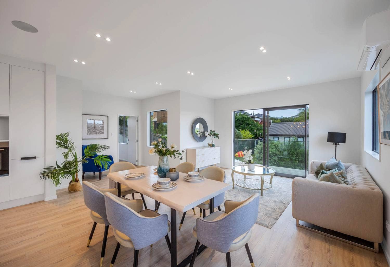 Dining table with the living area beyond and windows on two walls, Torbay