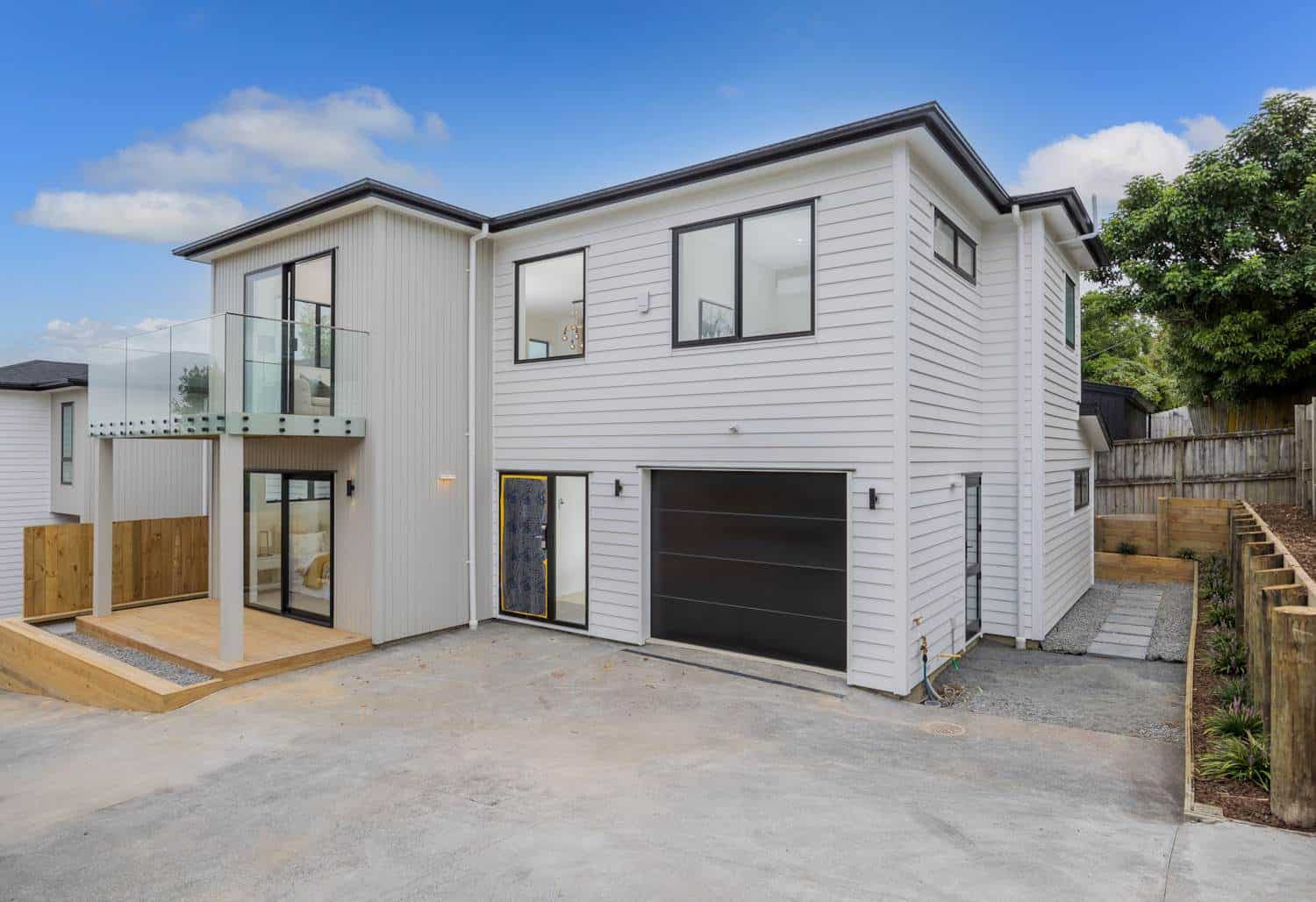 Two-storey house with a single garage, glass-balustraded balcony and paved drive, Torbay
